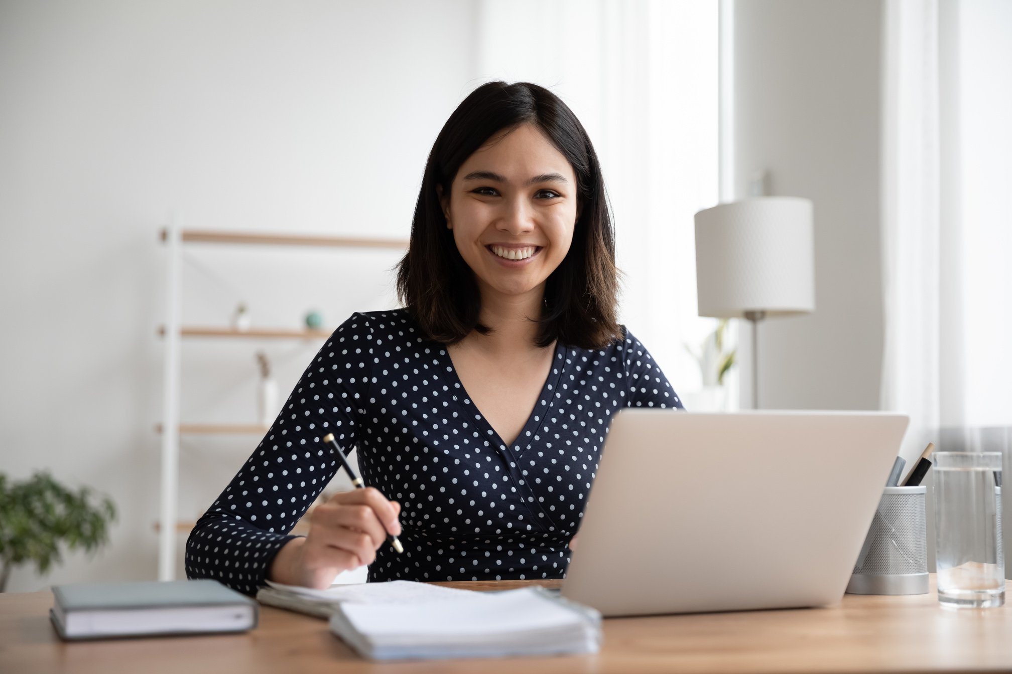 Happy asian mixed race student studying distantly on online courses.